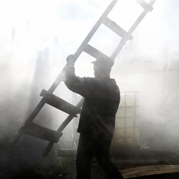 The Wider Image: Charcoal burners hope to keep the fire alight