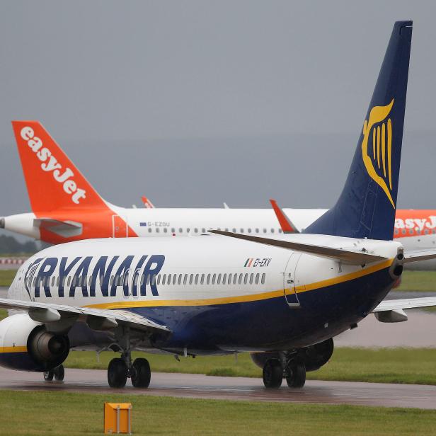 FILE PHOTO: A Ryanair aircraft taxis behind an easyJet aircraft at Manchester Airport