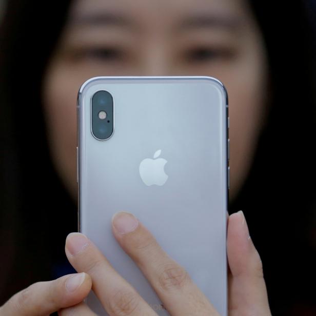 FILE PHOTO: An attendee uses a new iPhone X during a presentation for the media in Beijing