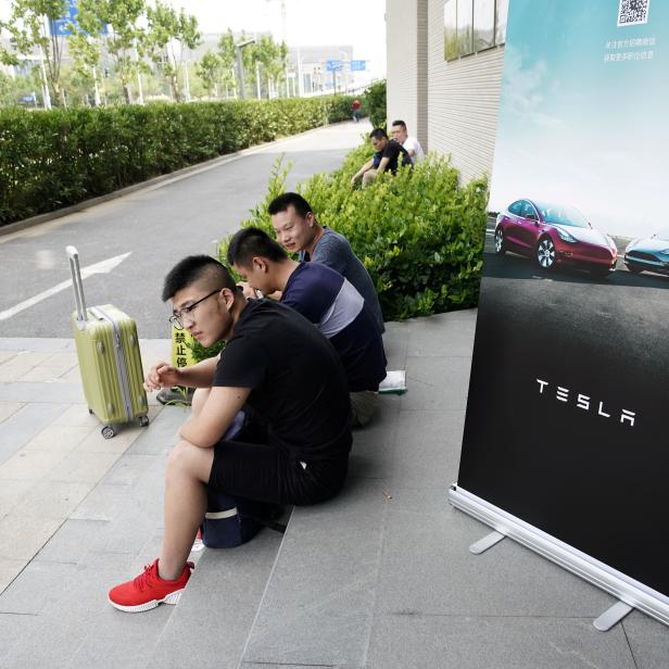 FILE PHOTO: People sit as they wait for job interviews at a job fair for Tesla Gigafactory in Shanghai