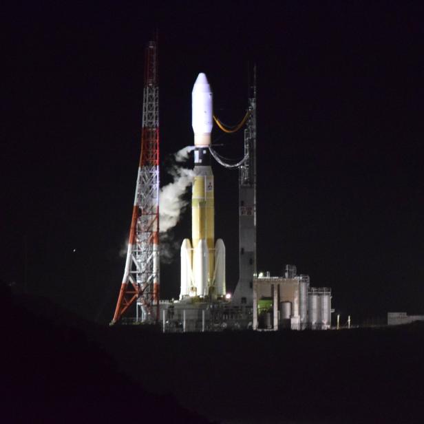 Eine Rakete steht nachts auf einer Startrampe und ist bereit zum Abheben.