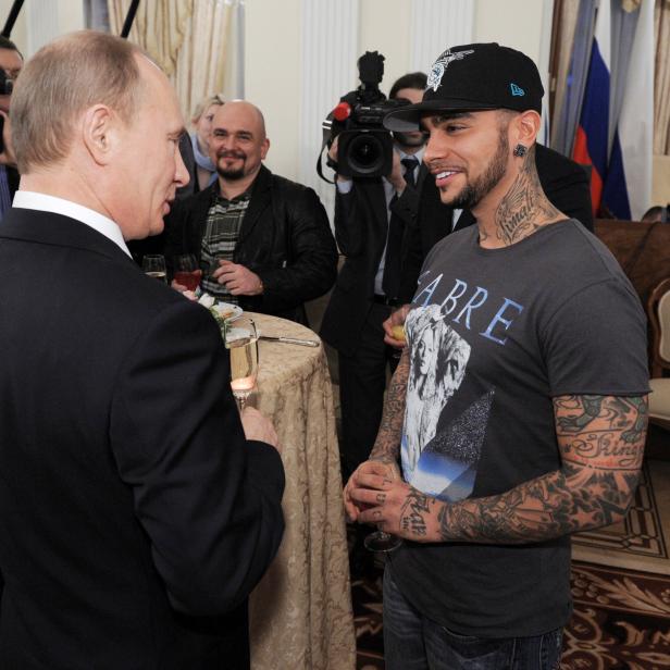 FILE PHOTO: Russian PM Putin talks to rapper Timati during a meeting with his supporters in Moscow