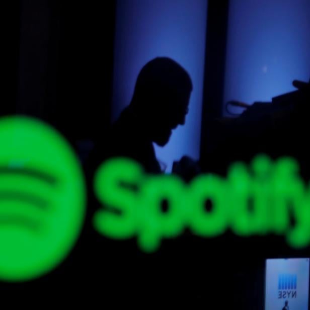 FILE PHOTO: FILE PHOTO: A trader is reflected in a computer screen displaying the Spotify brand before the company begins selling as a direct listing on the floor of the New York Stock Exchange in New York