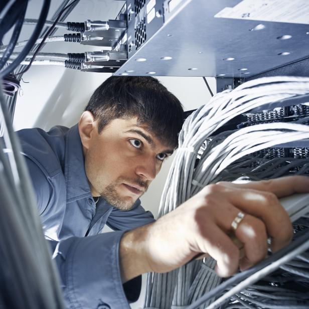 Technician engeneer is checking server's wires in data center