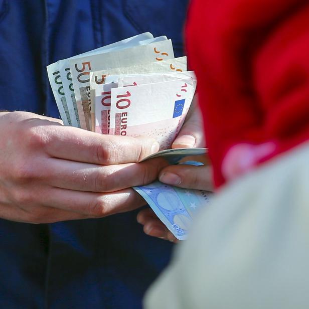 A customer counts money as he waits to buy Apple Watch at store in Berlin, file