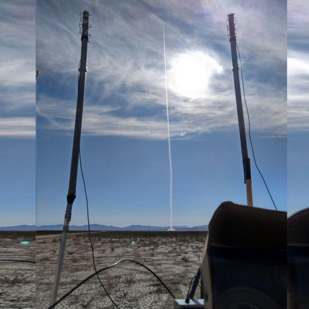 Eine Rakete steigt in der Wüste vor blauem Himmel auf.