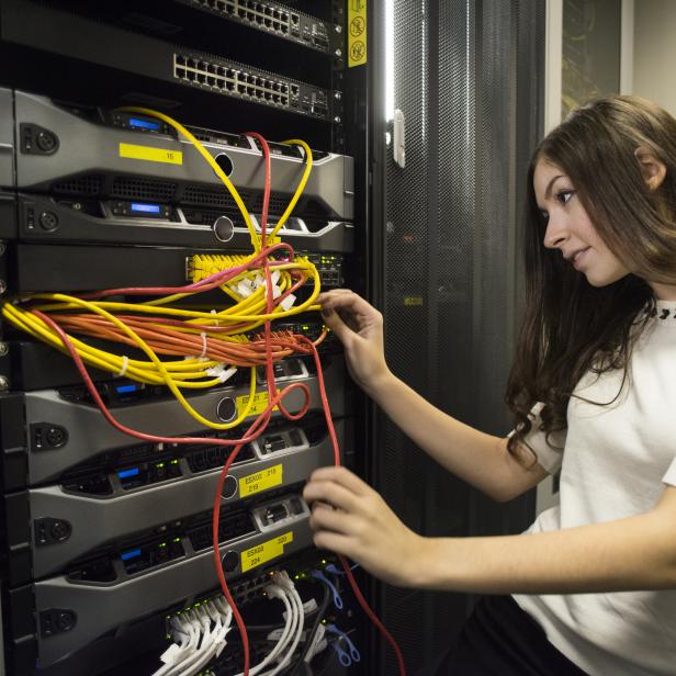 IT worker in server room patching cables