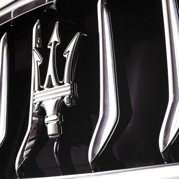 Detailansicht des Kühlergrills eines Maserati mit dem Dreizack-Logo.