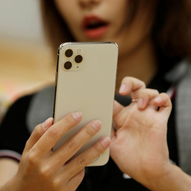 A woman holds an iPhone 11 Pro Max after it went on sale at the Apple Store in Beijing