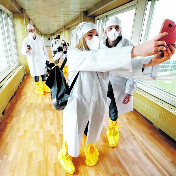 Journalists take a selfie in a corridor of stopped third reactor at the Chernobyl nuclear power plant in Chernobyl