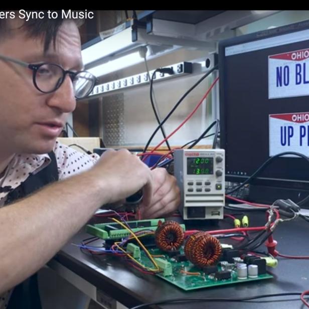 Ein Mann arbeitet an einer elektronischen Schaltung mit Spulen und Kabeln.