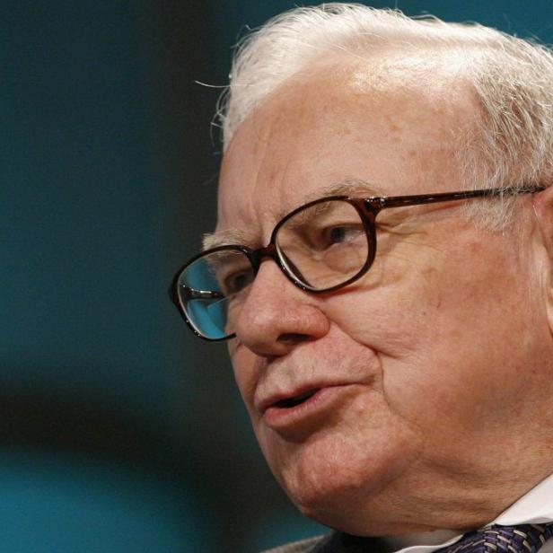 Warren Buffett spricht vor einem blauen Hintergrund.