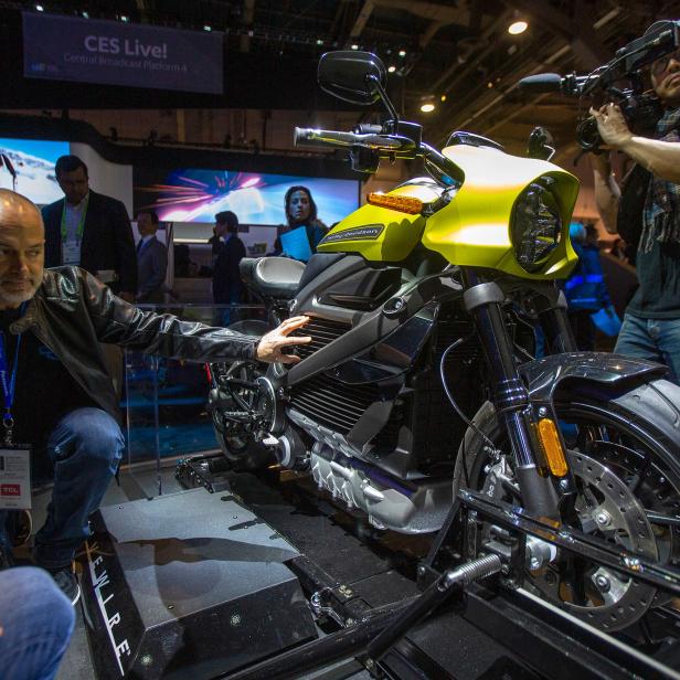 Ein Mann betrachtet ein Harley-Davidson-Motorrad auf einer Messe.