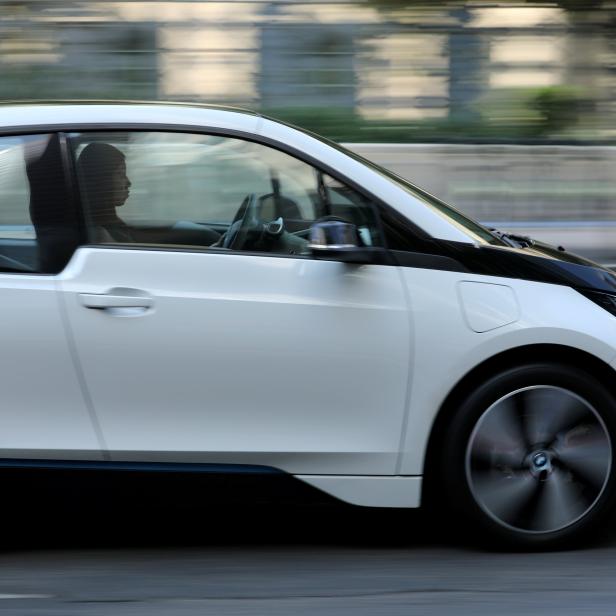 FILE PHOTO: A women drives an electric BMW i3 vehicle along a downtown street in Los Angeles,