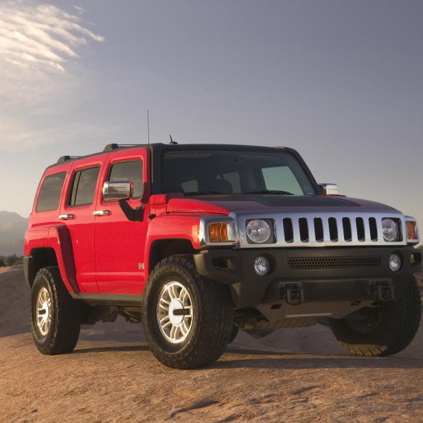 Ein roter Hummer H3 steht auf einer Felsformation.
