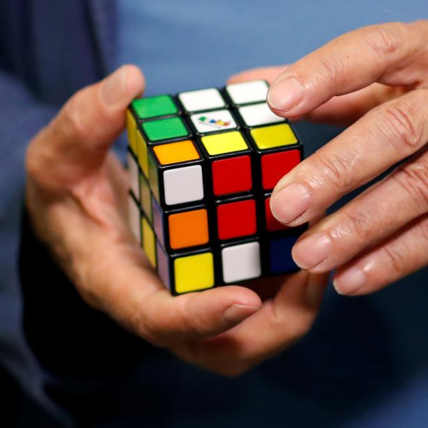 FILE PHOTO: Rubik solves a Rubik's cube as he poses during the world's largest Rubik's Cube championship in Aubervilliers