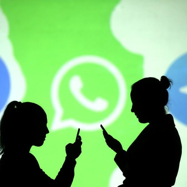 Silhouettes of mobile users are seen next to logos of social media apps Signal, Whatsapp and Telegram projected on a screen in this picture illustration