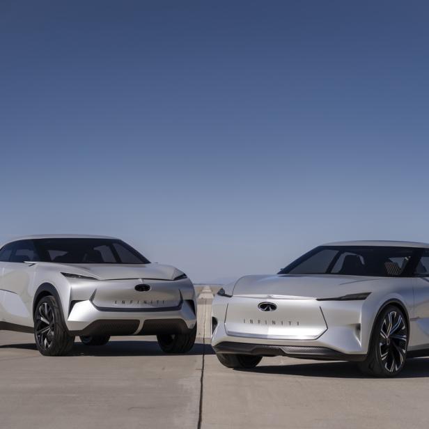 Zwei silberne Infiniti-Konzeptfahrzeuge stehen vor einem blauen Himmel.