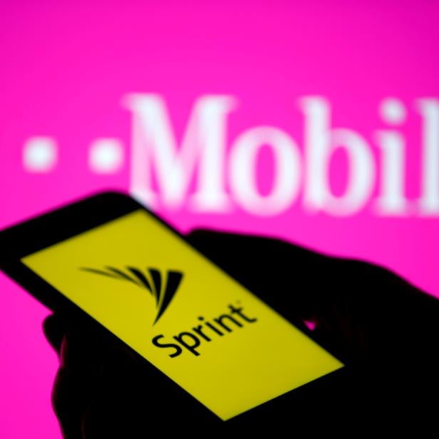 FILE PHOTO: A smartphone with Sprint logo are seen in front of a screen projection of T-mobile logo, in this picture illustration