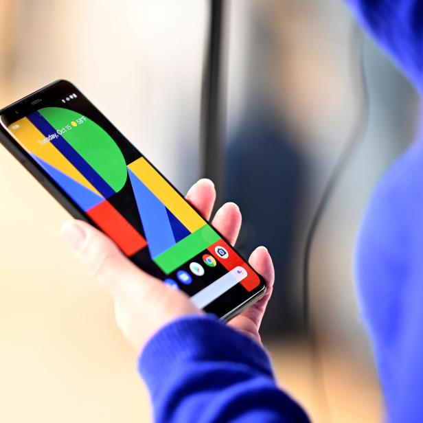 Eine Person hält ein Google Pixel Smartphone mit einem farbenfrohen geometrischen Hintergrundmuster.