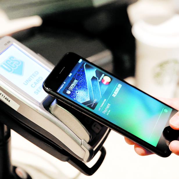 FILE PHOTO: Man uses iPhone 7 smartphone to demonstrate mobile payment service Apple Pay at cafe in Moscow