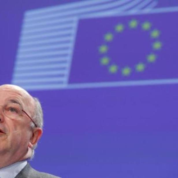 Ein Mann spricht vor einer Wand mit der EU-Flagge.