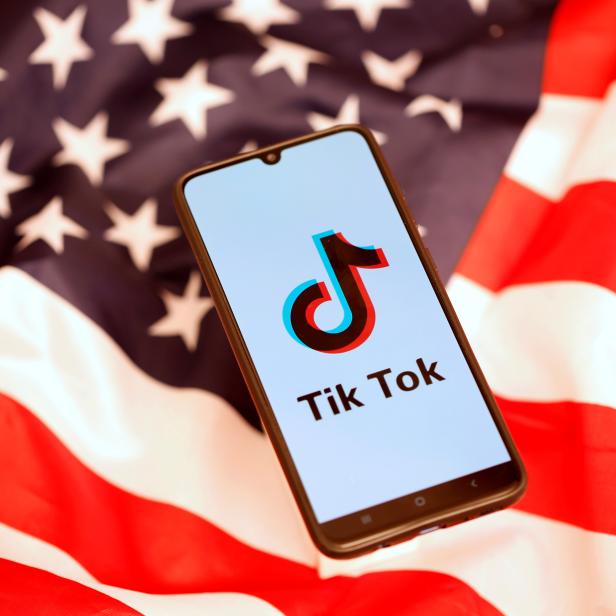 FILE PHOTO: TikTok logo is displayed on the smartphone while standing on the U.S. flag in this illustration