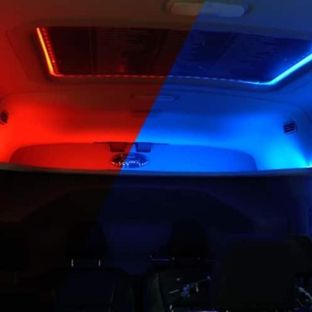 Innenraum eines Fahrzeugs mit roter und blauer LED-Beleuchtung.