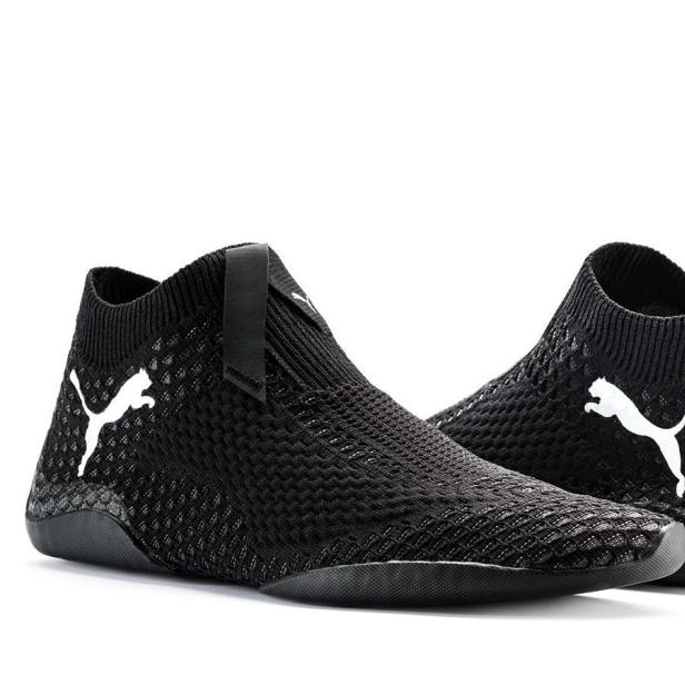 Zwei schwarze Puma-Schuhe mit weißem Logo stehen vor einem weißen Hintergrund.