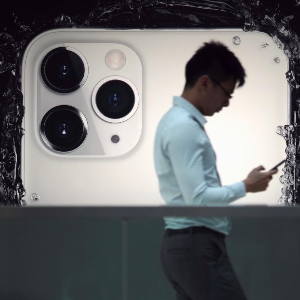 A man walks next to an advertisement for Apple's new iPhone 11 Pro at the Apple Store in IFC, Central district, Hong Kong, China