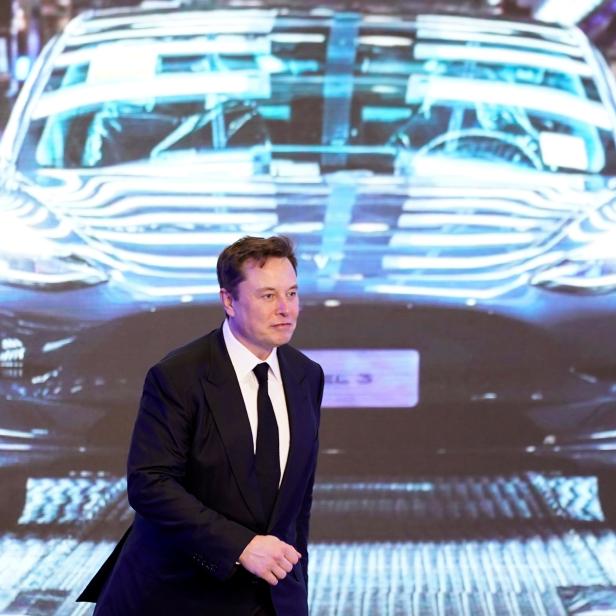 Tesla Inc CEO Elon Musk walks next to a screen showing an image of Tesla Model 3 car during an opening ceremony for Tesla China-made Model Y program in Shanghai