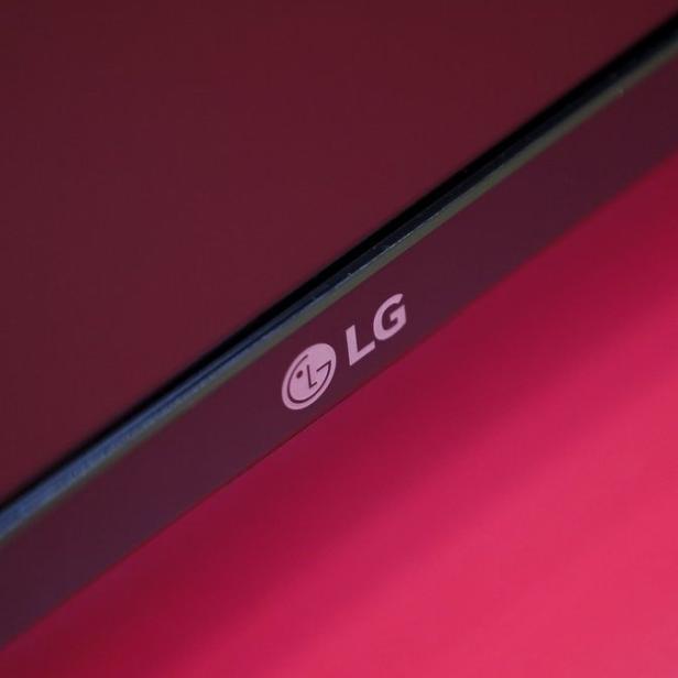 Das LG-Logo auf einem schwarzen Bildschirm vor einem roten Hintergrund.