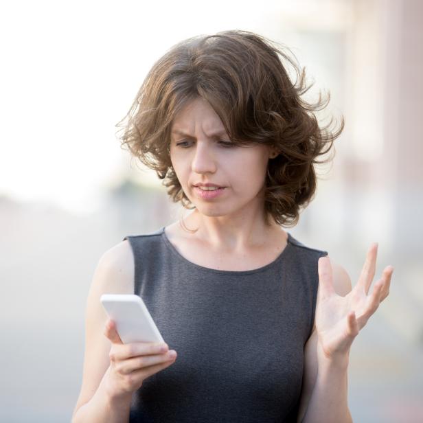 Young business woman irritated with her phone