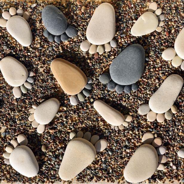 Pebble stones arranged like footprints on the beach