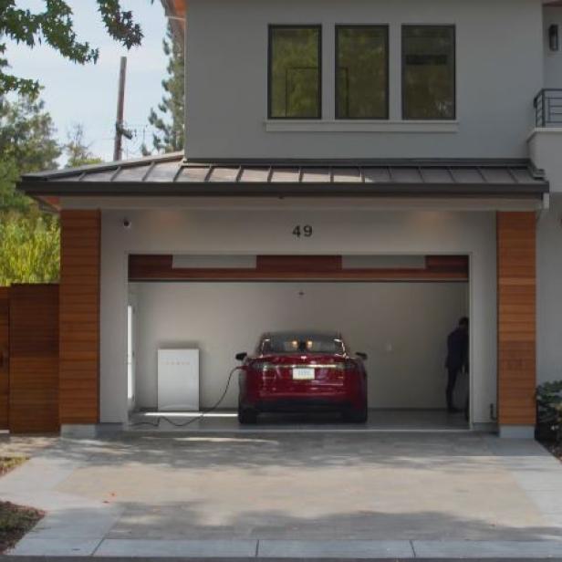 Ein rotes Tesla-Auto wird in einer Garage mit der Nummer 49 aufgeladen.
