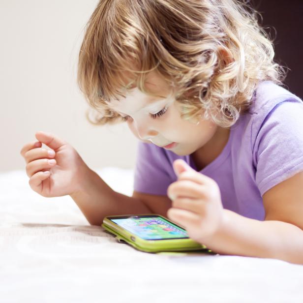 Cute little girl playing with smartphone.