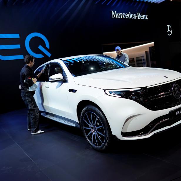 Ein Mann wischt einen weißen Mercedes-Benz EQC 400 4Matic auf der Canadian International AutoShow in Toronto ab.