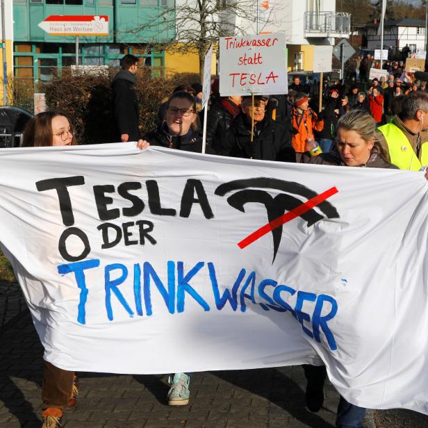 Demonstrators hold anti-Tesla posters during a protest against plans by U.S. electric vehicle pioneer Tesla to build its first European factory and design center near Berli