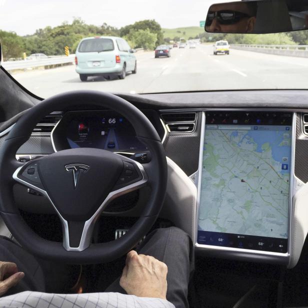 The interior of a Tesla Model S is shown in autopilot mode in San Francisco