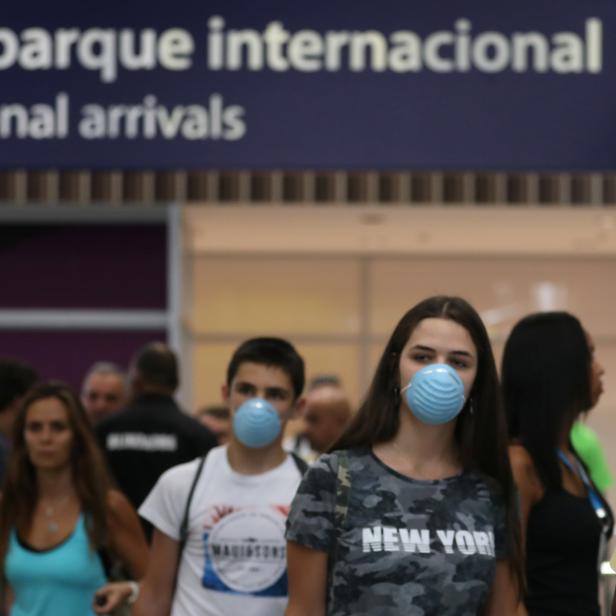 Passengers wearing masks, following the coronavirus outbreak in China, arrive at the Tom Jobim International Airport in Rio de Janeiro