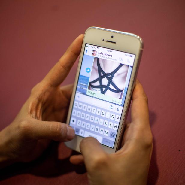 Eine Person hält ein Smartphone mit einer Nachricht über Shibari von Lulu Barrera.