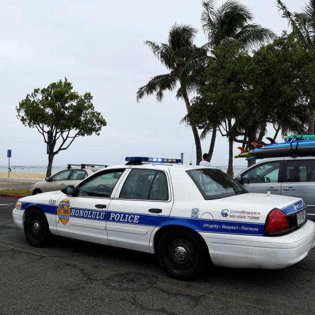 A Honolulu police car drives thru Ala Moana beach park warning beach goers as Hurricane Lane approaches Honolulu.