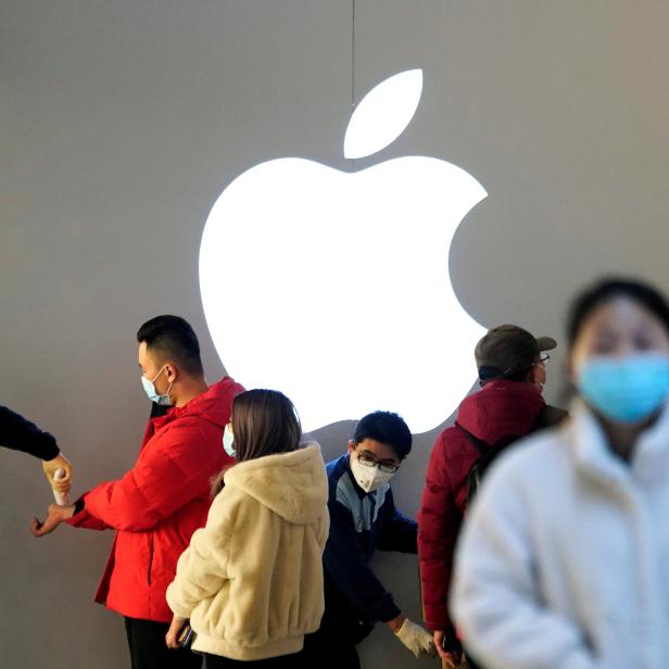 FILE PHOTO: People wearing protective masks wait for checking their temperature in an Apple Store, in Shanghai