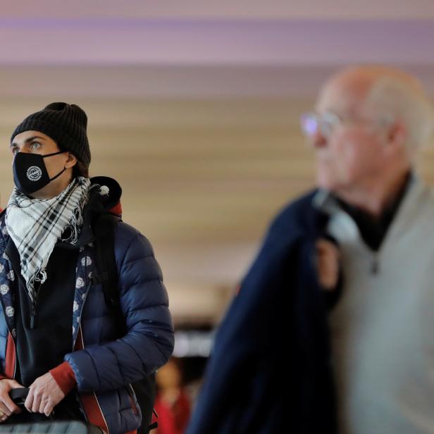 A traveler wears a mask in John F Kennedy International Airport in New York