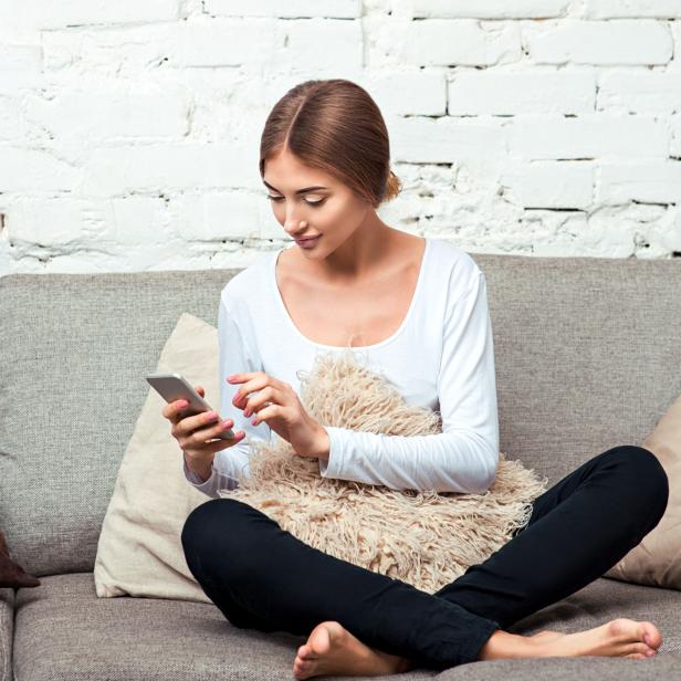 Woman with a mobile phone on couch