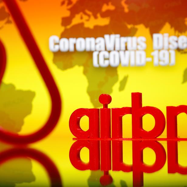A 3D printed Airbnb logo is seen in front of displayed coronavirus disease (COVID-19) writing in this illustration