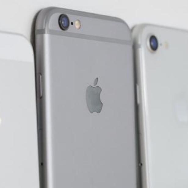 Eine Reihe von iPhones verschiedener Modelle und Farben liegen nebeneinander.