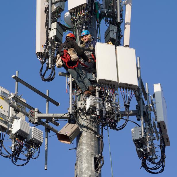 A crew from Verizon installs 5G equipment on a tower in Orem