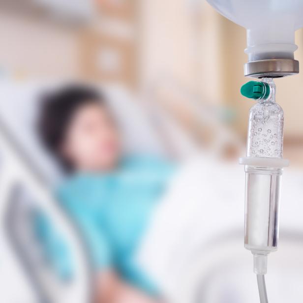 Medical drip with patient in the hospital blurred background