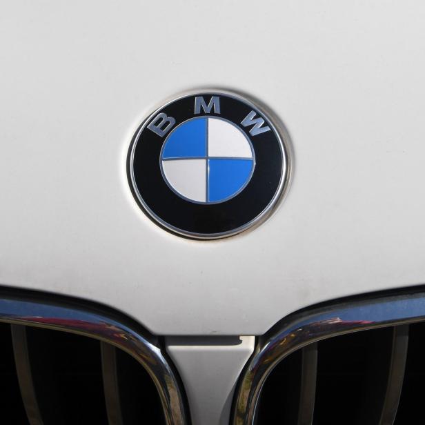 Detailaufnahme des BMW-Logos und des Kühlergrills eines weißen Autos.